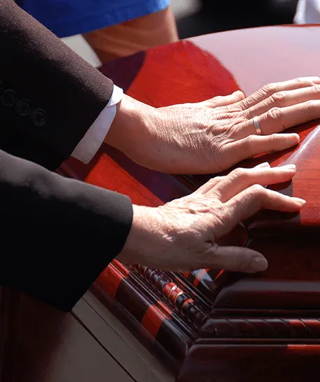 a person's hands on a coffin