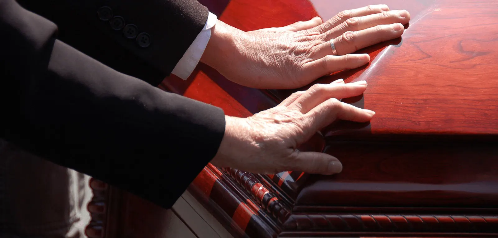 a person's hands on a coffin