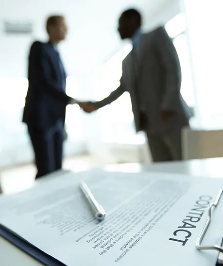 a pen on a paper with a couple of men shaking hands