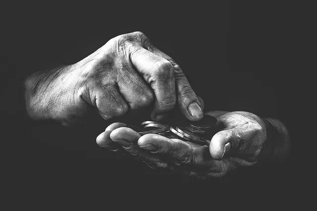 a close-up of a person's hands holding coins