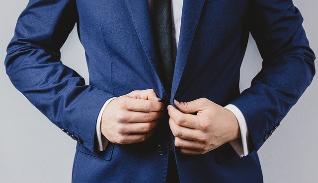 businessman 4914044 640 a man buttoning a suit